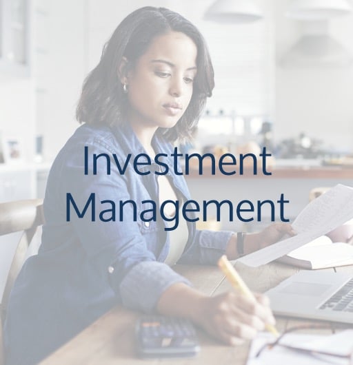 Investment Management - women at kitchen counter with papers, laptop, writing something down